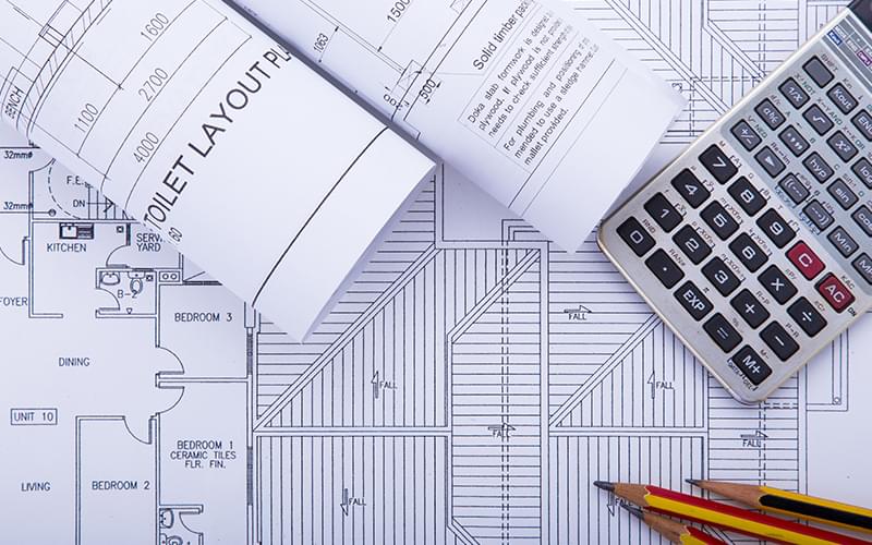 Blueprints, a calculator, and pencils for a home improvement project